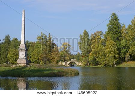 GATCHINA, RUSSIA - SEPTEMBER 24, 2015: View on the Chesme obelisk and the Humpback bridge, september day. Historical landmark of the city Gatchina