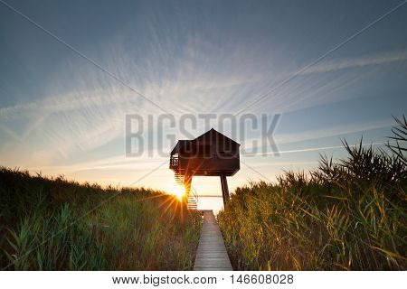 sunbeams behind wooden observation tower Nieuwe Statenzijl Netherlands