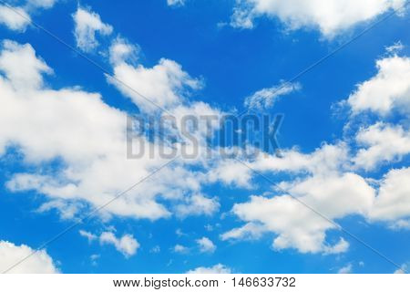 Sky and clouds. White fluffy cumuli clouds in the blue sky.