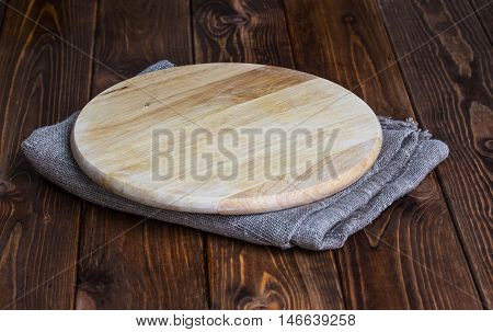 Round chopping board on dark wooden table