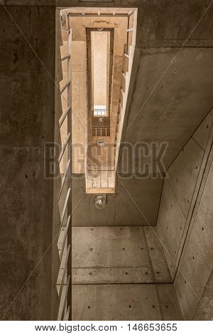Looking up on cement modern stairway stairs with symmetrical lines