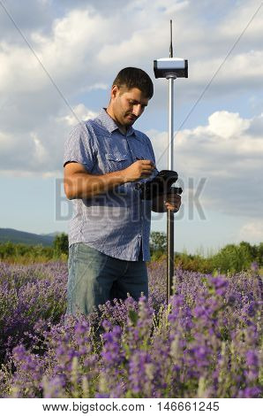 Surveyor working in a lavender field with GPS