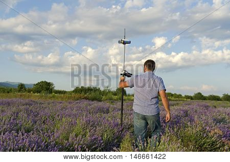 Surveyor walking in a lavender field with controller