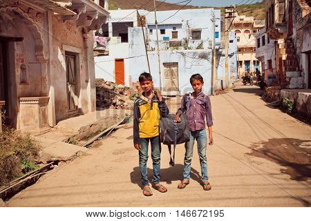 BUNDI, INDIA - FEB 17, 2015: Unidentified children pose outdoor with huge big bag on February 17, 2015 in Rajasthan. 17th century Bundi Palace is situated on hill adjacent to Taragarh Fort