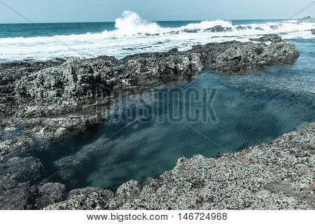 Rocky ocean coastline tidal water pools in vintage landscape.