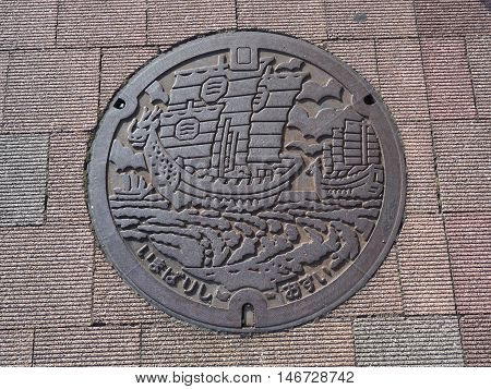 EHIME, JAPAN - JULY 20, 2016: A manhole cover in Imabari, Ehime Prefecture, Japan. The ancient sails were engraved on a manhole cover.