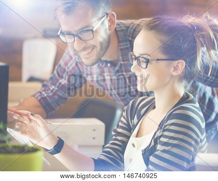 Young Casual business couple using computer in the office. Two colleagues working together on an innovative product design in a creative studio. Coworking, Creative manager showing new startup idea