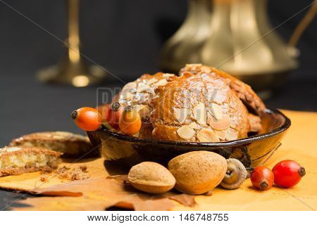 Typical Dutch filled spicy cookies with almonds on autumn colored and dark background