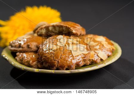 Typical Dutch filled spicy cookies with almonds on autumn colored and dark background
