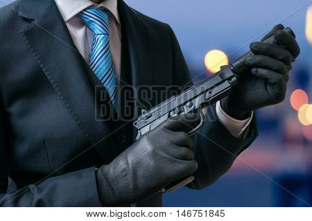 Secret Agent Holds Pistol With Silencer In Hands At Twilight.