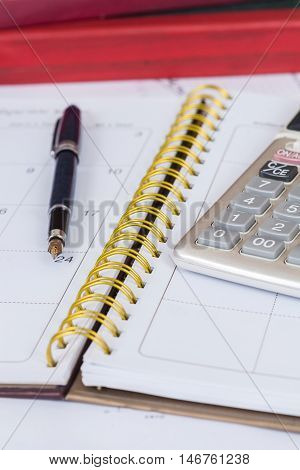 calculate and pen on calendar book on table
