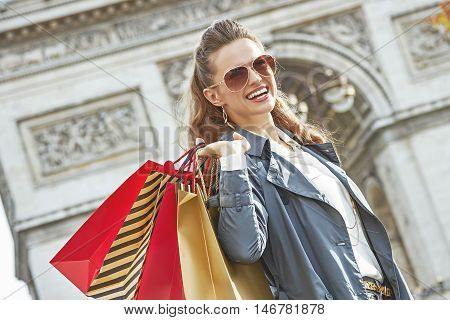 Smiling Woman With Shopping Bags In Paris Looking Into Distance