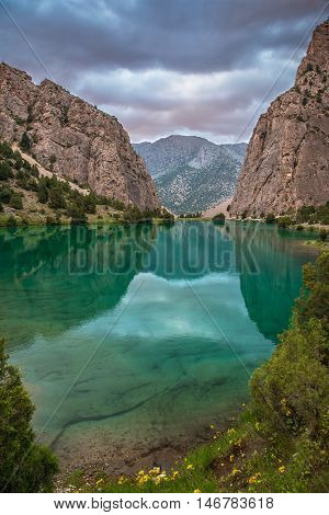 Green and transparent Chukurak lake surrounded with mountains (Tajikistan Fann Mountains).