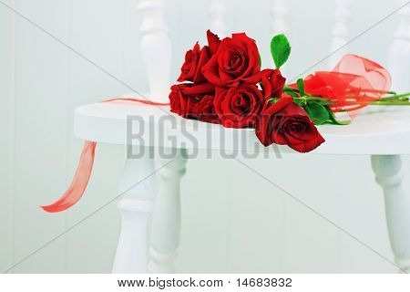Rosas vermelhas em uma cadeira branca