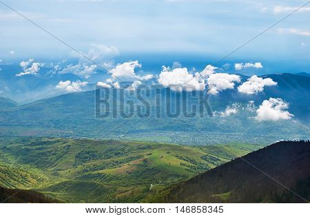 Landscape with clouds mountains blue sky and village. Carpathians Ukraine.