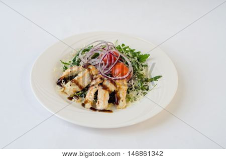 chicken salad with arugula, onion and sauce on the plate
