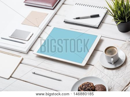 Mockup of a tablet pc on office desk, next to pens, pencils and so on. Clipping path for tablet included.