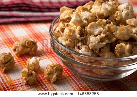 caramel popcorn in a glass bowl on a napkin close up