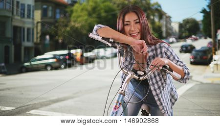 Chinese woman sitting on bike outdoors in San Francisco