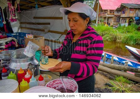 PASTO, COLOMBIA - JULY 3, 2016: unidentified woman adding some caramel to a wafer in a location close to la cocha lake.