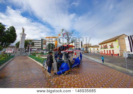 TULCAN, ECUADOR - JULY 3, 2016: unidentified man waiting while another man clean his shoes on the central park of the city.