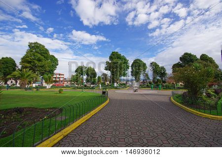 TULCAN, ECUADOR - JULY 3, 2016: cobble road that ends in a monument in the middle of a park.