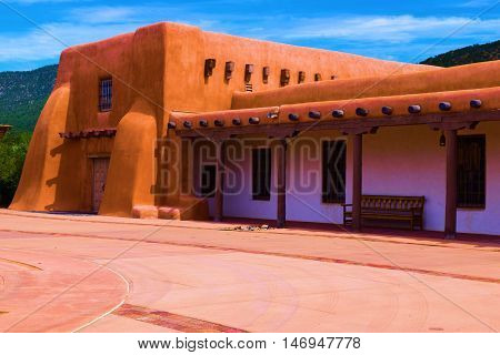 Building with adobe style architecture and mountains beyond taken in Santa Fe, NM