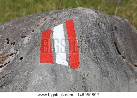 White and red trail sign painted on a Rock. Lech Valley. Austria