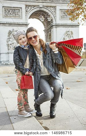Smiling Mother And Child With Shopping Bags In Paris, France