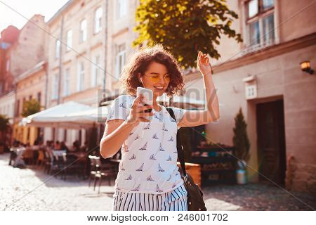 Beautiful Young Girl Using Smart Phone And Listening To The Music Walking On Street. Happy Woman Dan