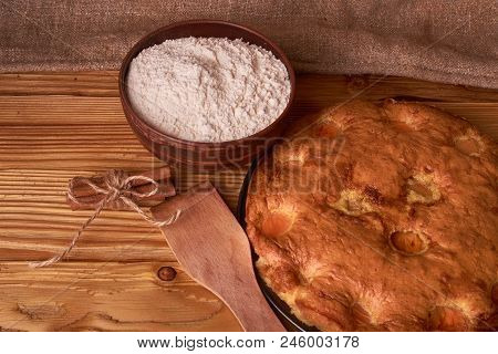 A Bowl With Flour And Apricot Cake On A Wooden Background On Black