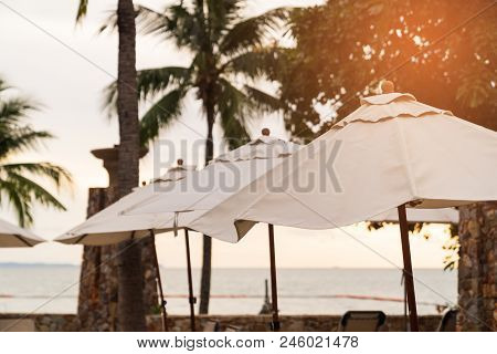 Lagre Umbrellas On The Sunset Beach Background, Vacation Holidays Resort Concepts.