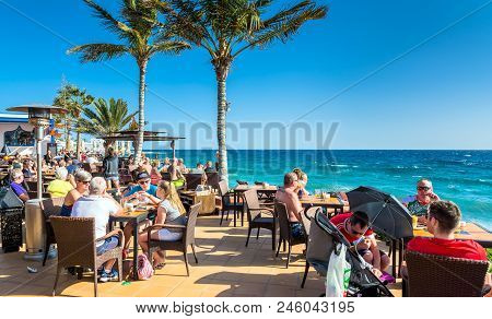 Puerto Del Carmen, Spain - December 29, 2016: Tourists Enjoy Drinks And Scenery At Cafe La Ola In Pu