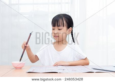 Asian Little Chinese Girl Practice Chinese Calligraphy At Home