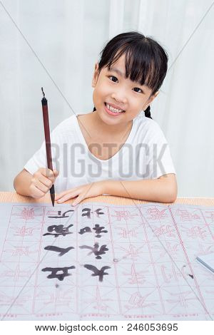 Asian Little Chinese Girl Practice Chinese Calligraphy At Home