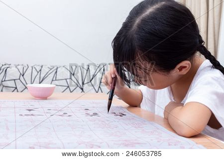 Asian Little Chinese Girl Practice Chinese Calligraphy At Home