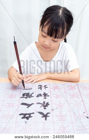 Asian Little Chinese Girl Practice Chinese Calligraphy At Home