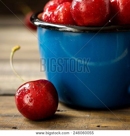 Fresh Cherry With Beautiful Drops In A Blue Enamel Mug
