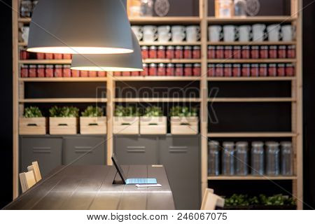 Digital Tablet And Smartphone On Wooden Table Desk In Working Area With Modern Lamps Overhead And De
