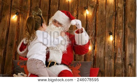 Cute Little Girl Pulling Santa's Beard To Check If It's Real Sitting On His Lap
