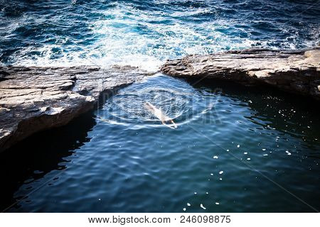 top view of woman swimming in natural sea water pool, Giola, Thassos island, Greece