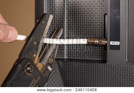 Close Up Of Senior Caucasian Man Hand Cutting The Aerial Connection To His Tv To Illustrate Cutting 