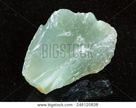 Macro Shooting Of Natural Mineral - Raw Prase (green Quartz) Stone On Black Granite From Ural Mounta