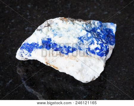 Macro Shooting Of Natural Mineral - Raw Lazurite (lapis Lazuli) Gemstone On Black Granite From Ural 