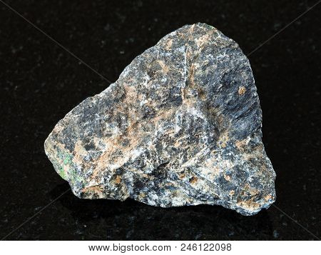 Macro Shooting Of Natural Mineral - Rough Chromite Stone On Black Granite From Ural Mountains
