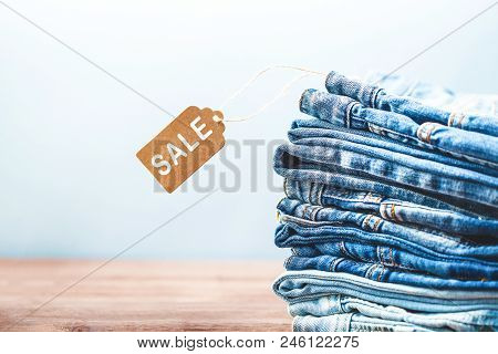 Concept Sales, Black Friday Discounts With Tag, Blue Jeans On A Light Background Copyspace.