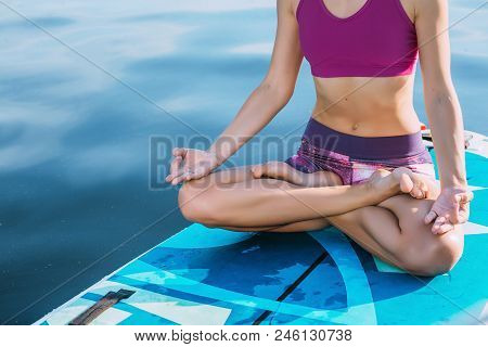 Unrecognizable Person Meditating On Paddle Board. Practice Yoga On Paddle Board, Woman Sitting On Pa