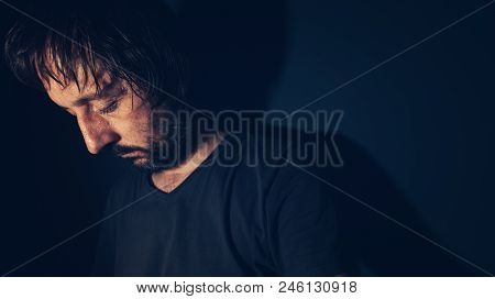 Mental Health And Depression Concept, Sad Depressed Man Sulking In Dark Interior