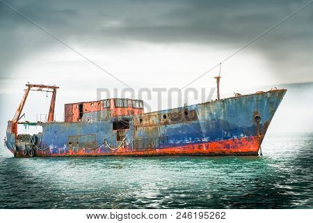 Rusting Hulk Of Small Ship In Harbor