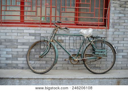 Beijing, China - March 12, 2016: At The Brick Wall Of The Building Is An Old Bike.